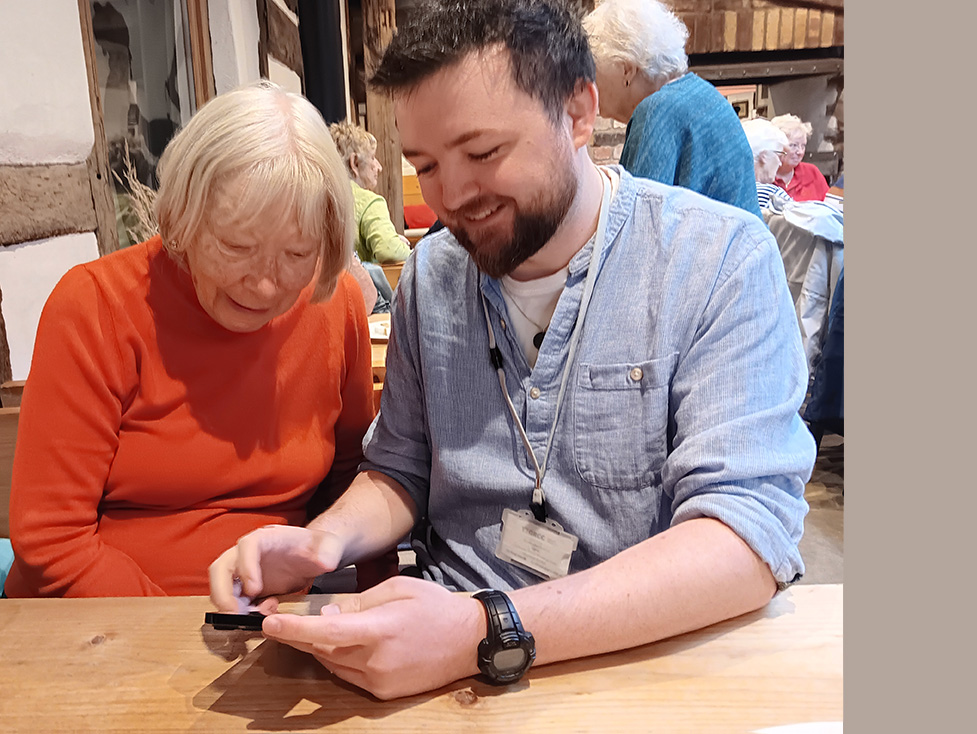 Josh helps an elderly drop-in client with her mobile phone