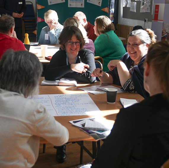 Community Buildings Network members working in small groups at a meeting